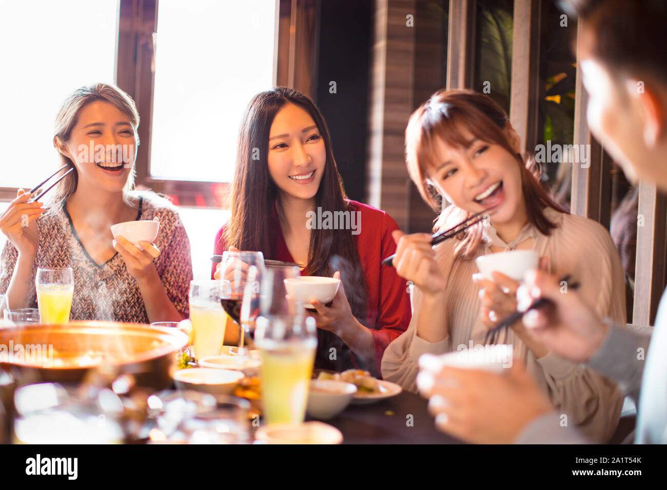happy young friends eating hot pot in restaurant Stock Photo