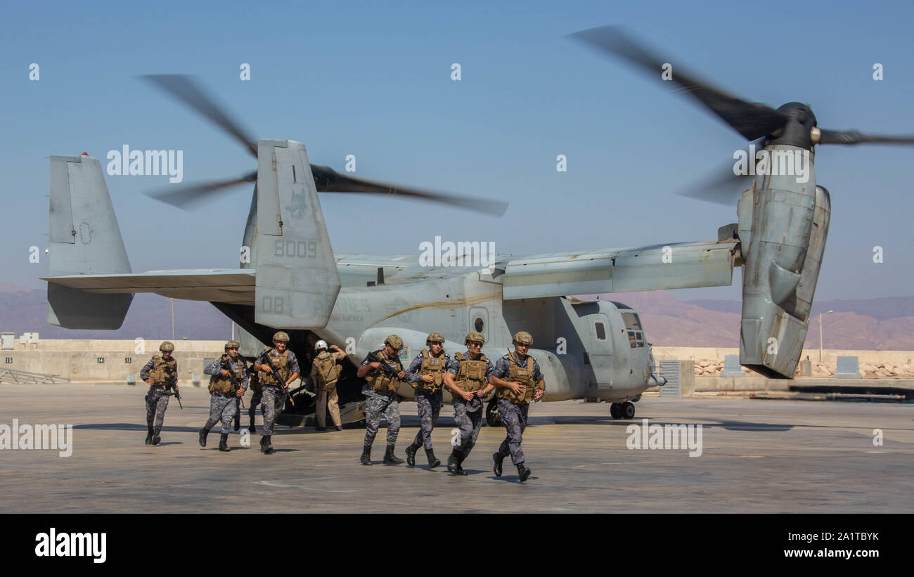 Members of the Royal Jordanian Marines offload a U.S. Marine Corps MV-22 Osprey attached to Special Purpose Marine Air-Ground Task Force-Crisis Response-Central Command, prior to conducting a simulated air-raid during the Middle East Amphibious Commanders Symposium, Jordan, Sept. 22, 2019. The SPMAGTF-CR-CC is designed to move with speed and precision to support operations throughout the Middle East. (U.S. Marine Corps photo by Cpl Rhita Daniel) Stock Photo