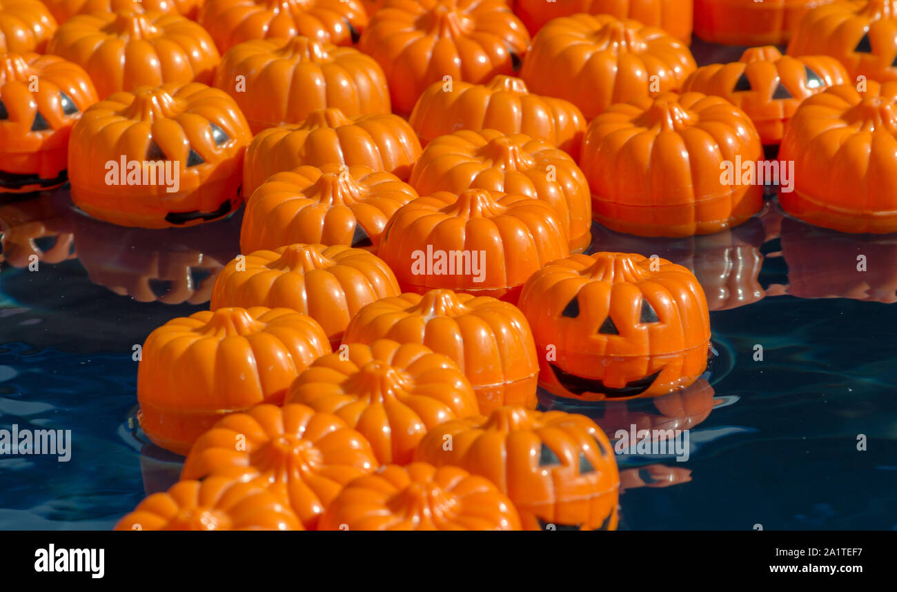 Little pumpkins are part of a fun fall game at a local carnival. Each floating jack-o-lantern has a number underneath it that corresponds with a prize Stock Photo