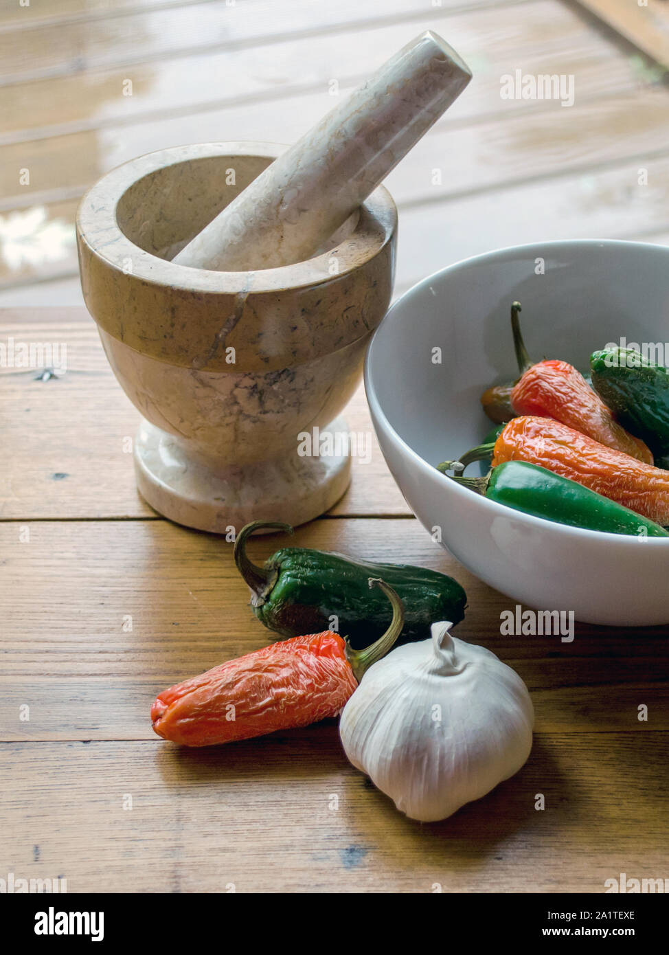 https://c8.alamy.com/comp/2A1TEXE/still-life-of-a-pestle-and-grinder-with-a-bowl-of-red-and-green-peppers-and-a-large-clove-of-garlic-2A1TEXE.jpg