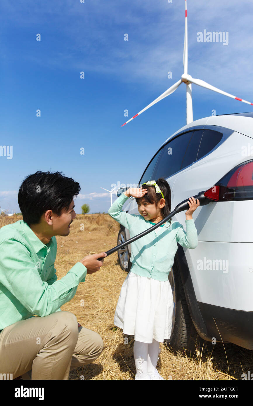 Father and daughter to car battery Stock Photo - Alamy