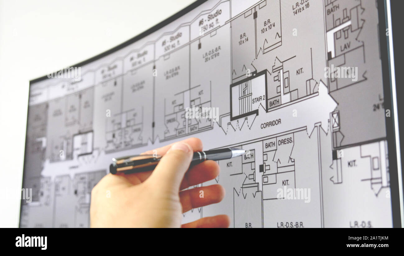 blueprint monitor hand pen explain plan of residential home apartment building on screen Stock Photo