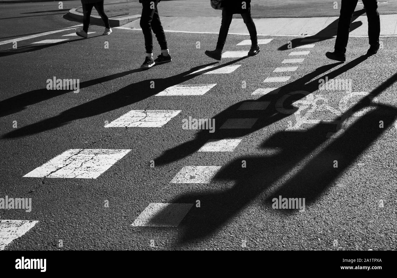 Black and white image of Silhouettes of a group of unrecognized pedestrian people crossing a road Stock Photo