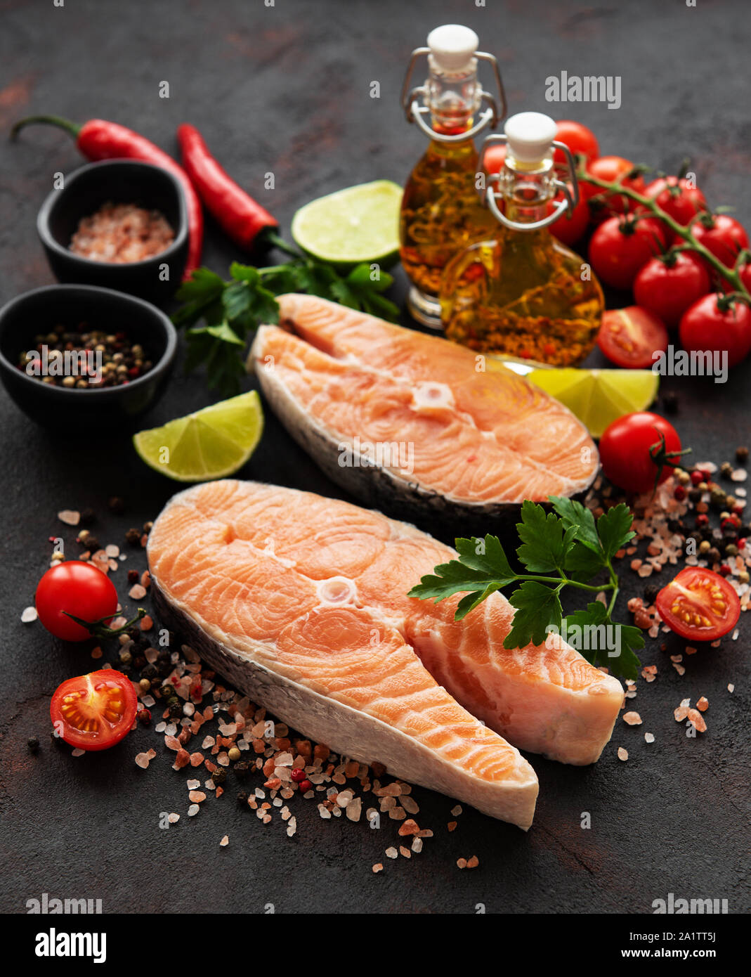 Raw salmon steaks and ingredients on a black slate board Stock Photo ...