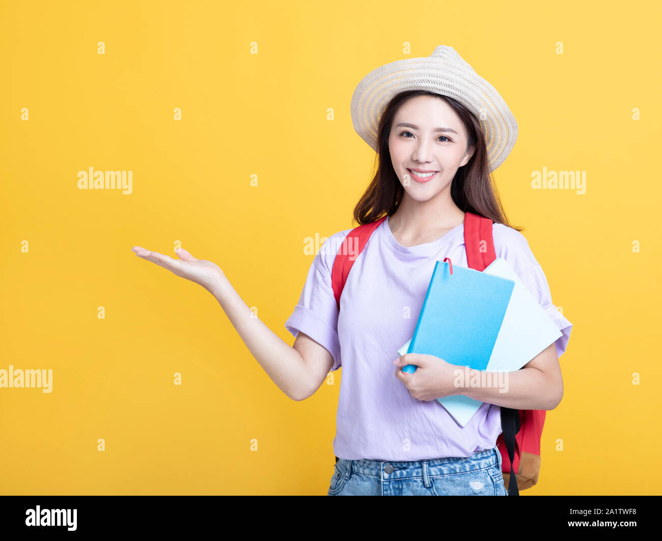 Young asian girl student holding book and showing Stock Photo - Alamy