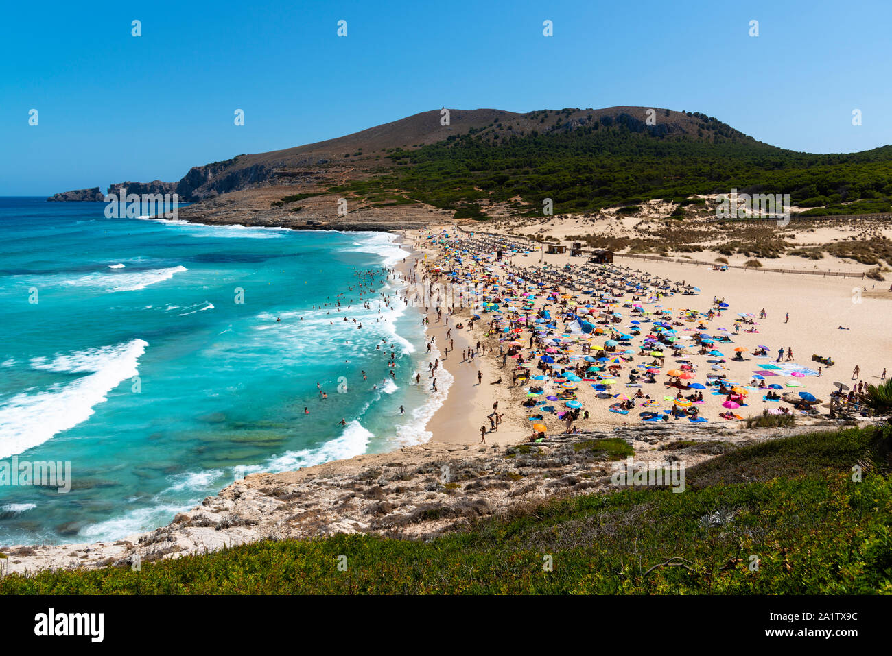 view on the beach of Cala Mesquida Majorca Spain with many tourists and rough sea Stock Photo
