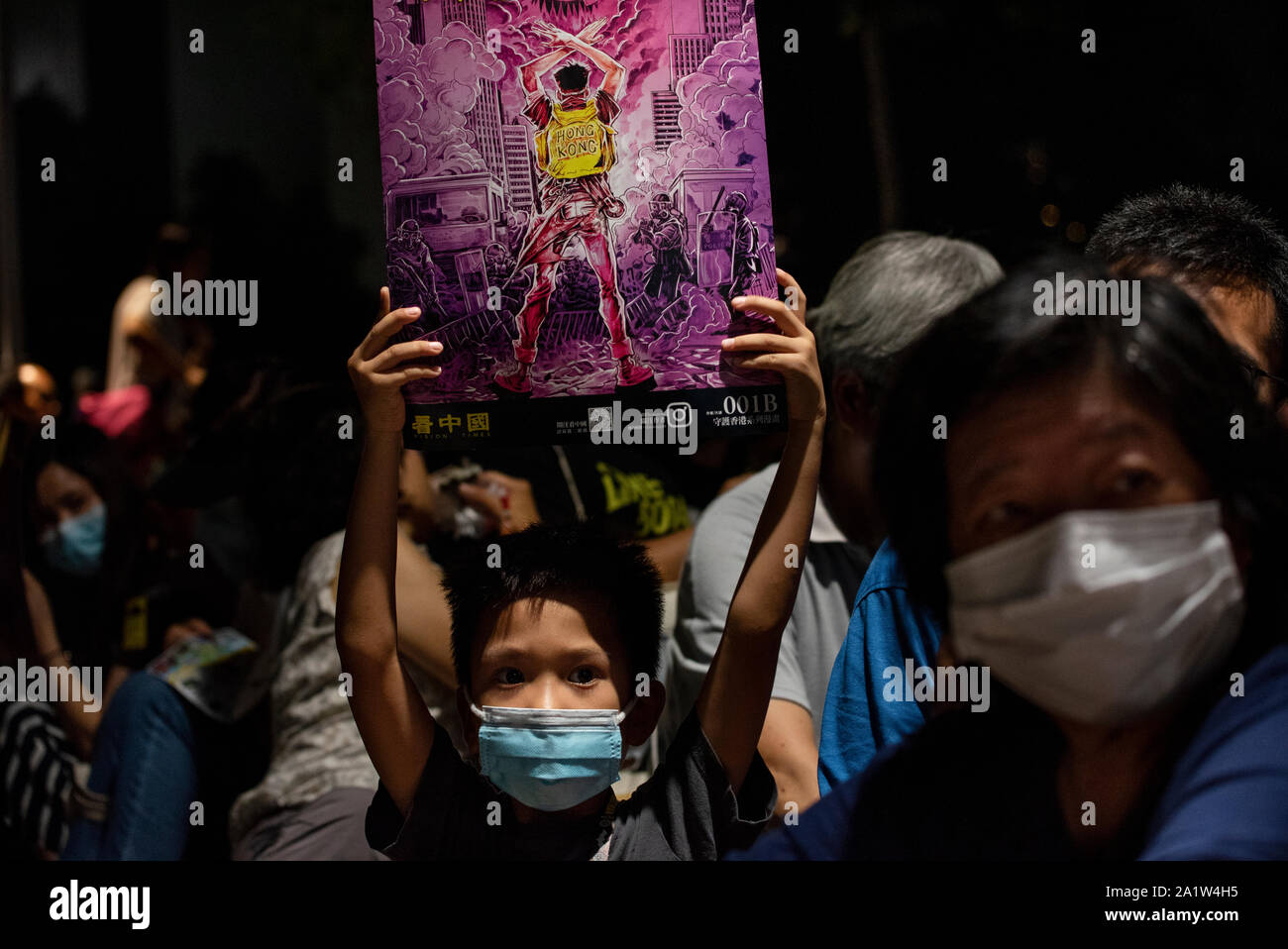 A kid holds a placard during the rally.Anti-government protesters commemorate the 5th anniversary of the Umbrella Movement at Tamar Park in Hong Kong. Stock Photo