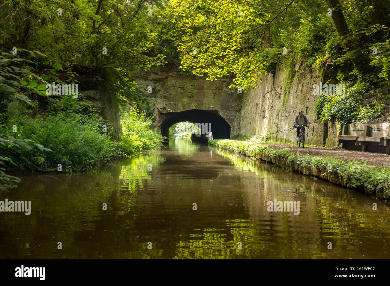 A man cycles along a towpath on The Shropshire Union Canal in England. Stock Photo