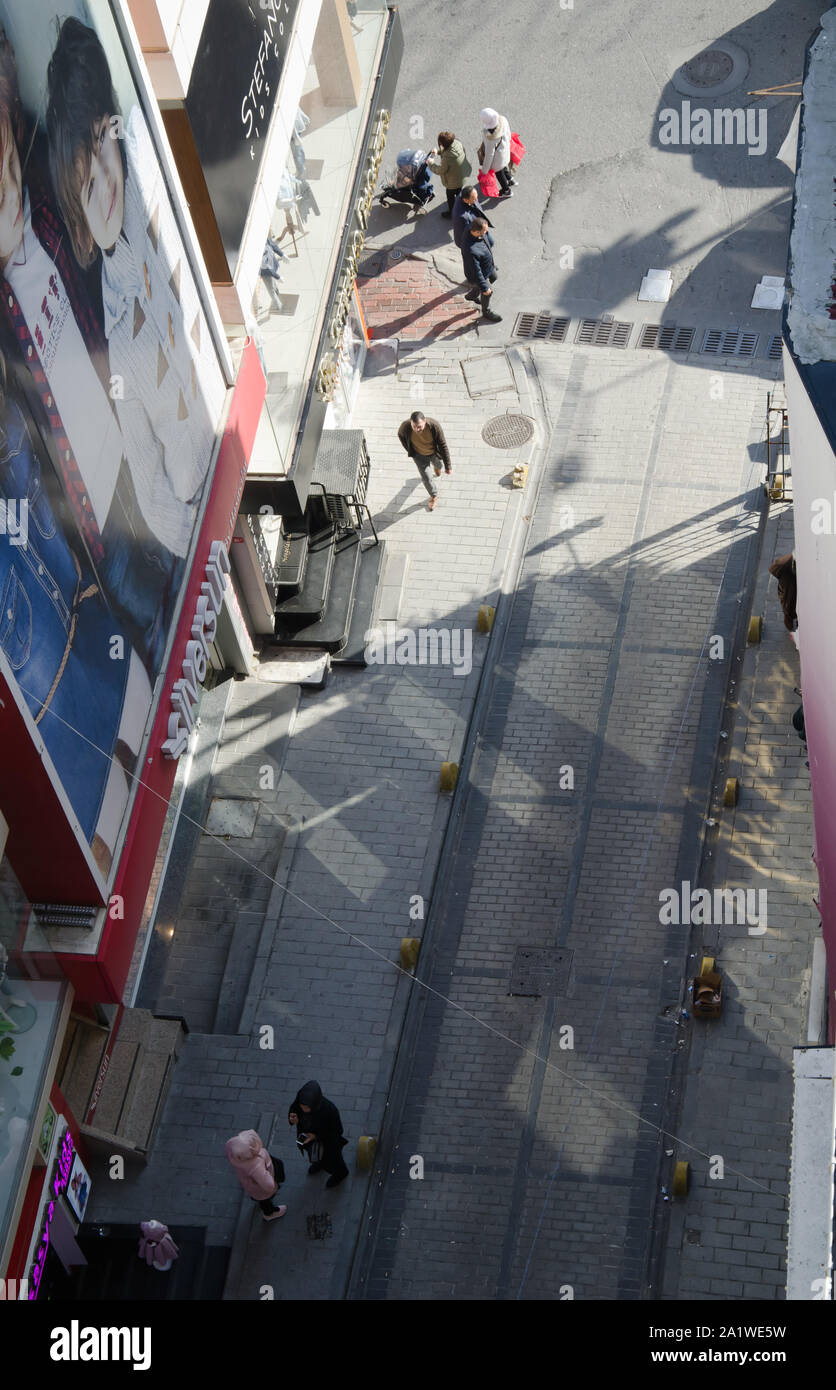 Istanbul,Turkey,March 07, 2019:top view on narrow cobblestone street with  passers-by,motorcyclist and workers transport goods,supplies for  stores Stock Photo