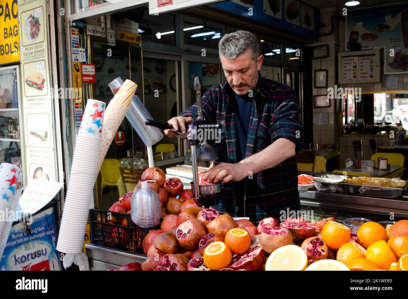 Istanbul Turkey March 08 2019 Seller with juicer making fresh juice pile of raw oranges and pomegranates on street market outdoor on sunny day Stock Photo Alamy