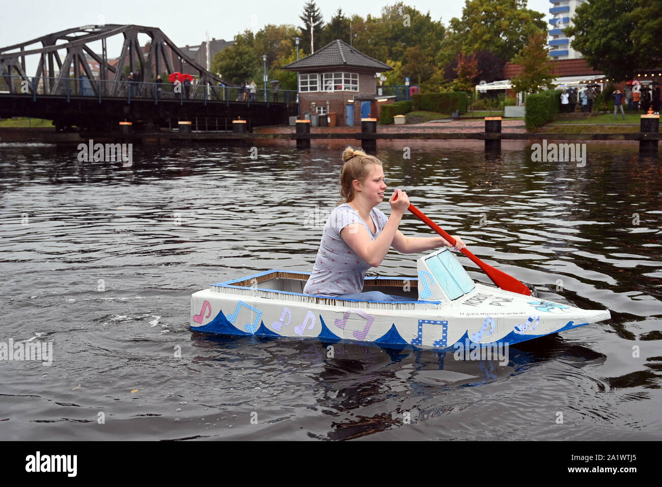 Wilhelmshaven, Germany. 29th Sep, 2019. The later winner Dana paddles at the PapierBootRegatta with her self-built paper boat on the Ems-Jade canal. The participants try to cover a distance of about 200 meters in the water to the finish line. The boats may only be made of cardboard, paper, tape and glue, only the paddles may be made of wood or plastic. Credit: Carmen Jaspersen/dpa/Alamy Live News Stock Photo