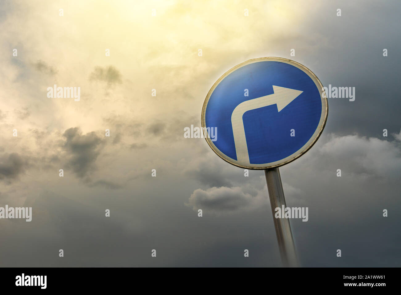 Turn right ahead sign, blue round roadside traffic signage, against the