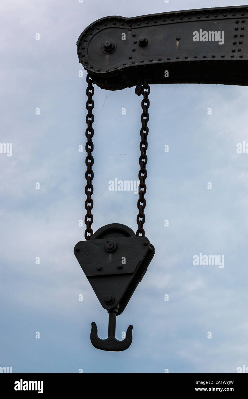 Old crane with chains made of steel Stock Photo