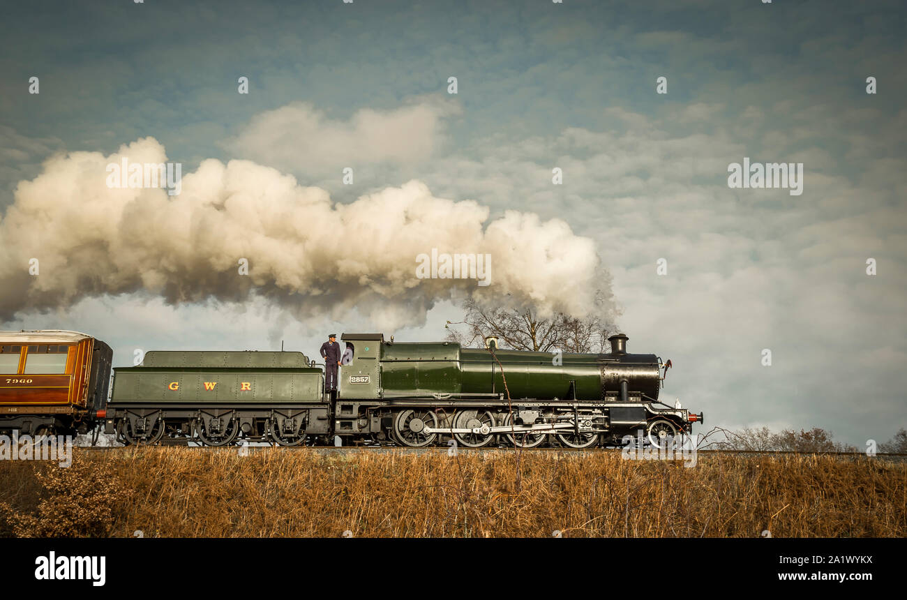 Side view, lowangle close up of vintage, UK steam train moving along