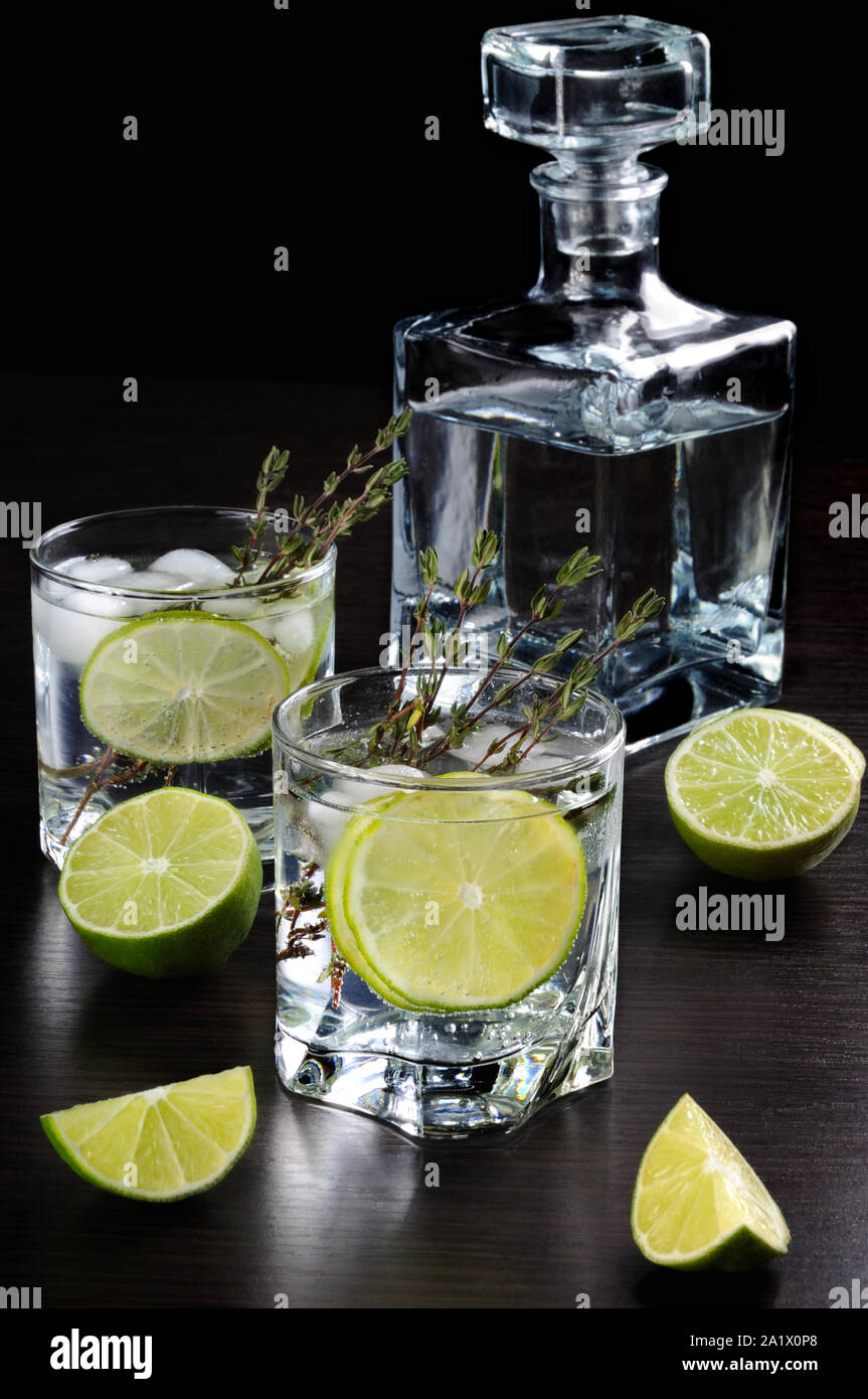 Cocktail with white rum and tonic, a slice of lime and thyme Stock