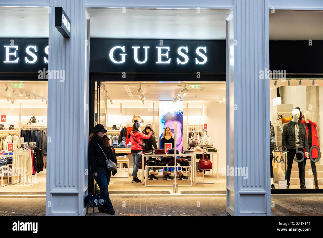 Athens, Greece - January 4, 2019: Display of a Guess store at night with  people around in Athens, Greece Stock Photo - Alamy