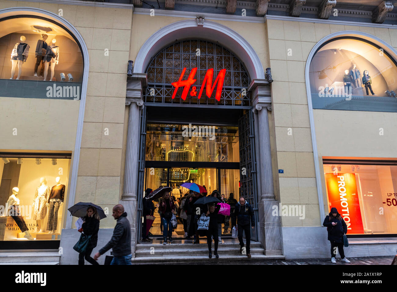 Athens, Greece - January 4, 2019: Display of a HM store at night with  people around in Athens, Greece Stock Photo - Alamy