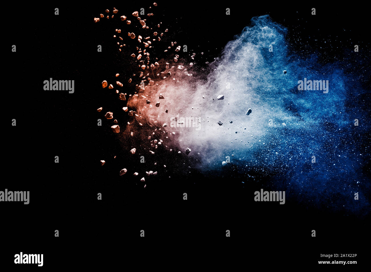 Split debris of stone exploding with blue red powder against black ...