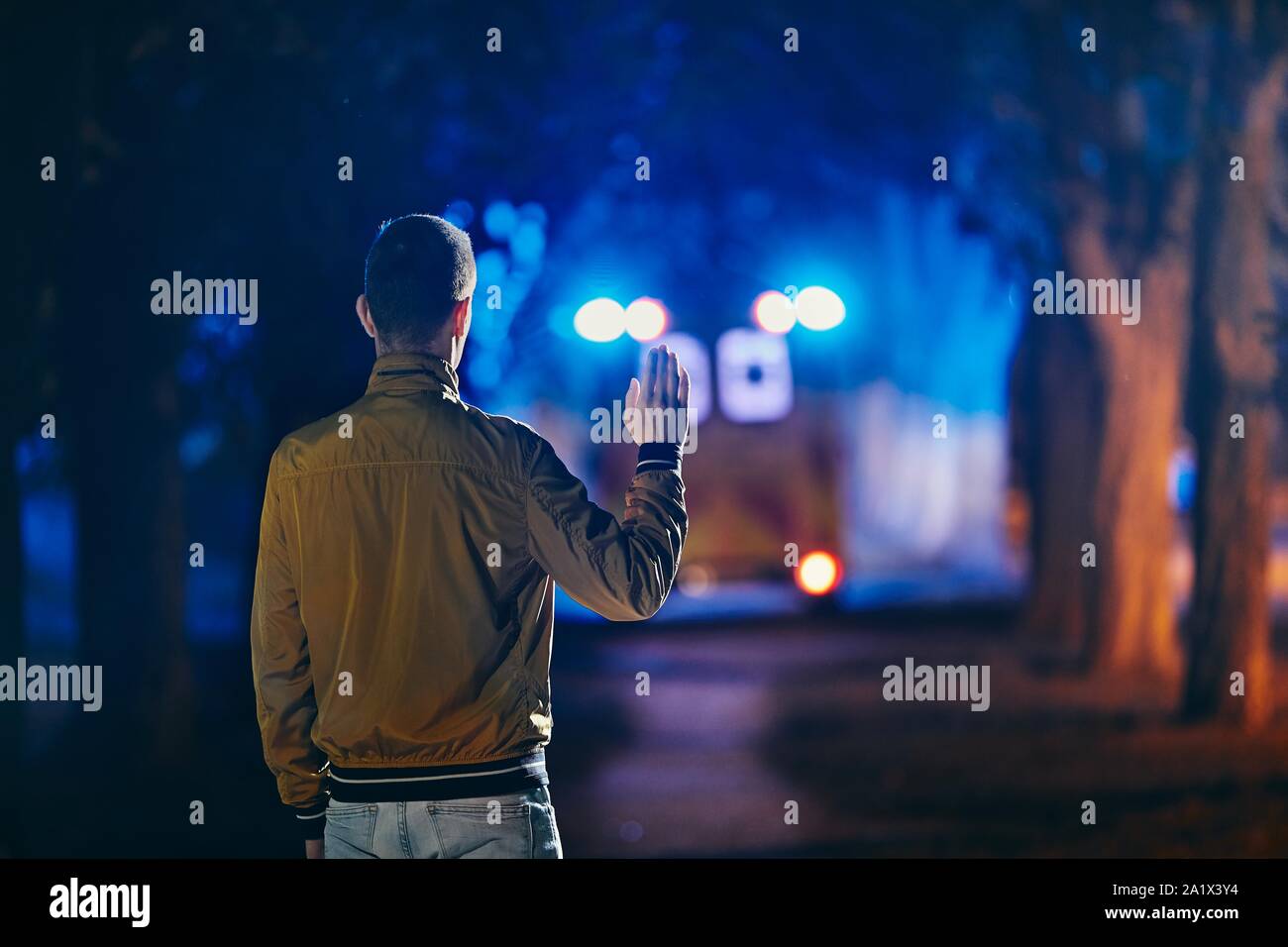 Young man looking at leaving ambulance car of emergency medical service. Concepts health care, rescue and goodbye. Stock Photo