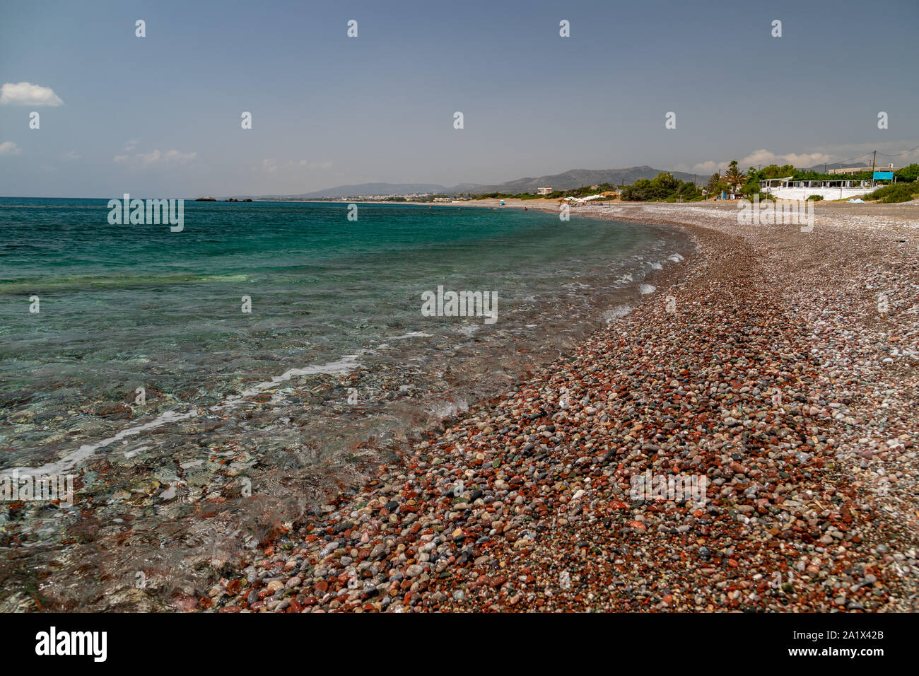Gravel beach at Kiotari on Rhodes island, Greece with stones in different colours and turquoise clear water Stock Photo