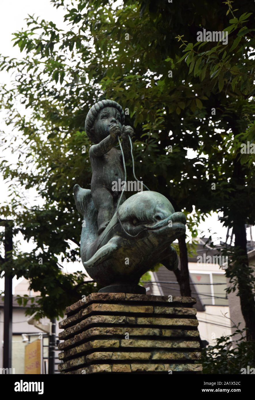Child riding dolphin statue,Shinjuku, tokyo, japan, asia Stock Photo