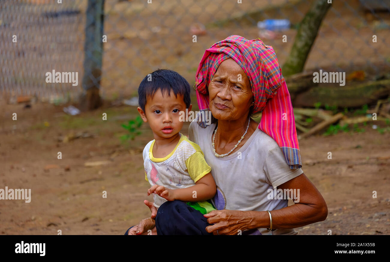 Portrait of a grandmother and grandson  at a poverty village in countryside of Vietnam.  Royalty high quality free stock image of portrait. Stock Photo