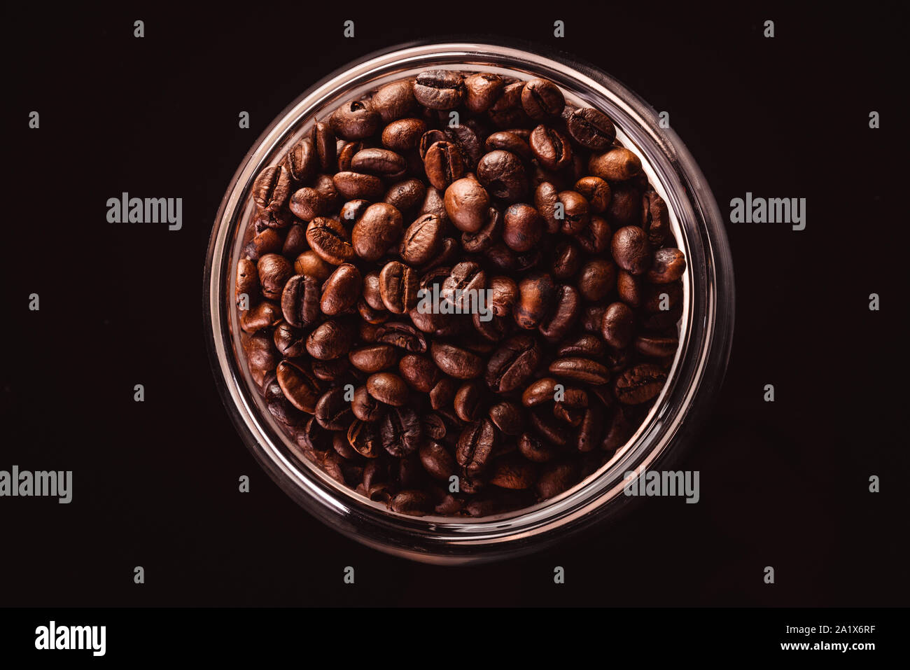 Coffee beans in glass jar standing on black background Stock Photo - Alamy