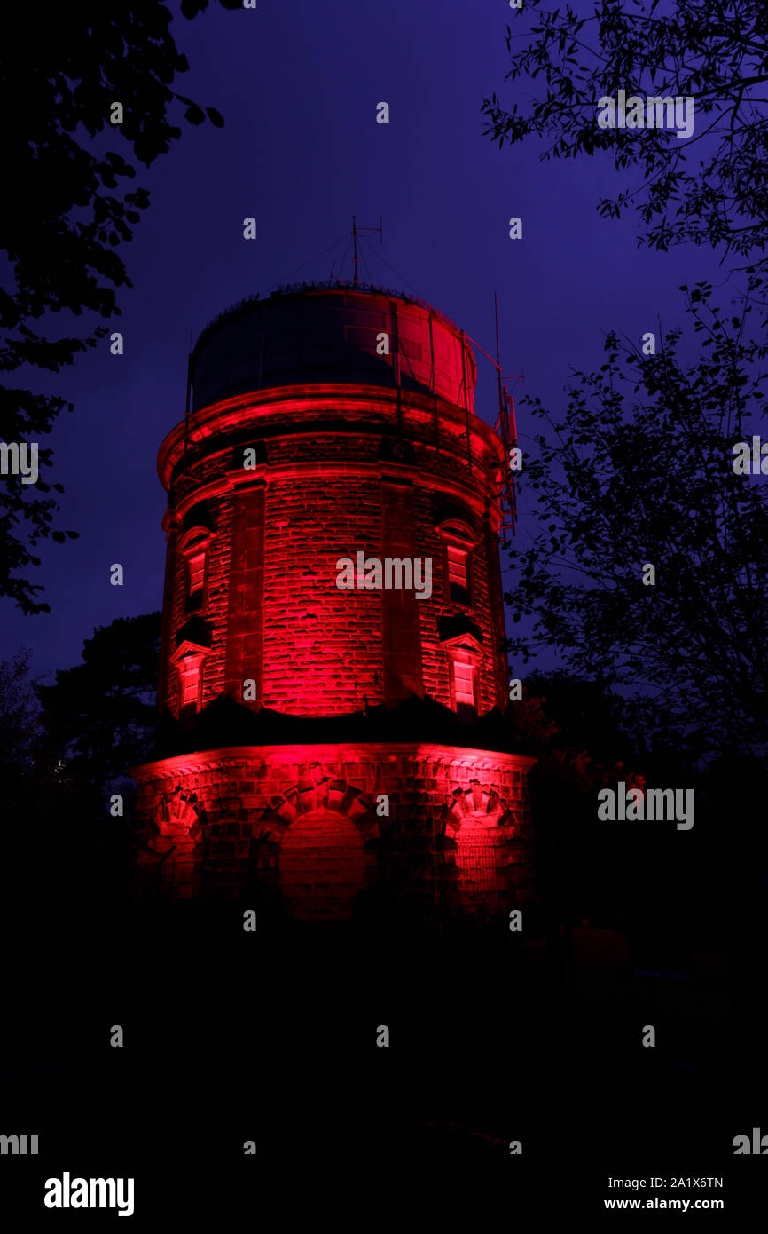 Red Floodlit Harlow Hill Water Tower (Observatory), Harrogate, North Yorkshire, England, UK. Stock Photo