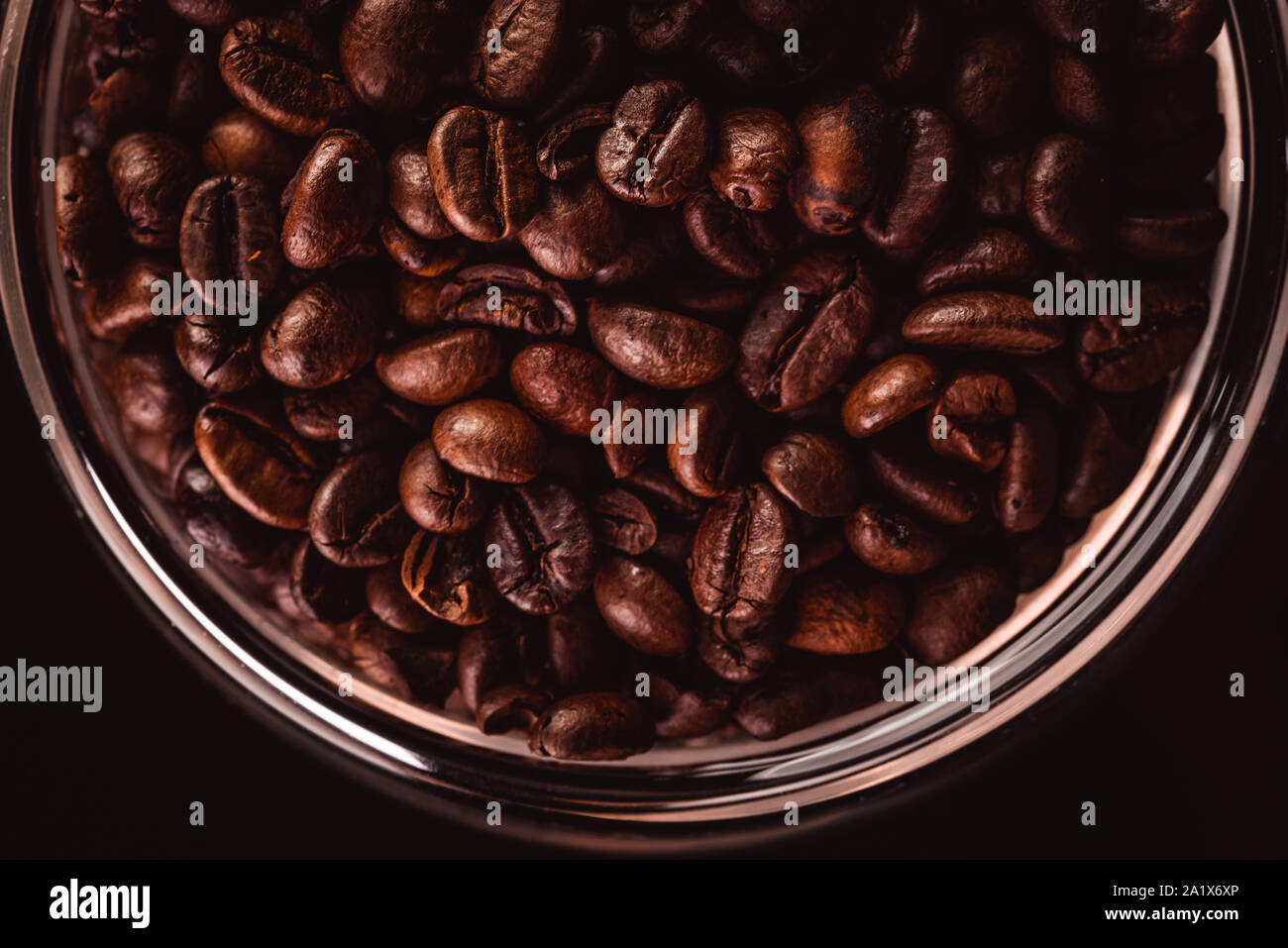 Coffee beans in glass jar standing on black background Stock Photo Alamy