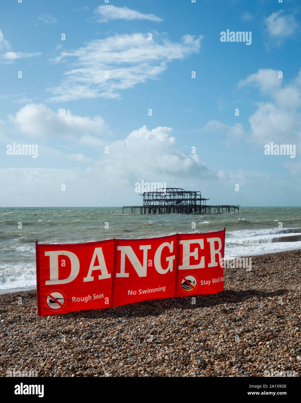 A wind-break displaying danger on Brighton beach because of high winds and rough seas. Brighton, East Sussex, England Stock Photo