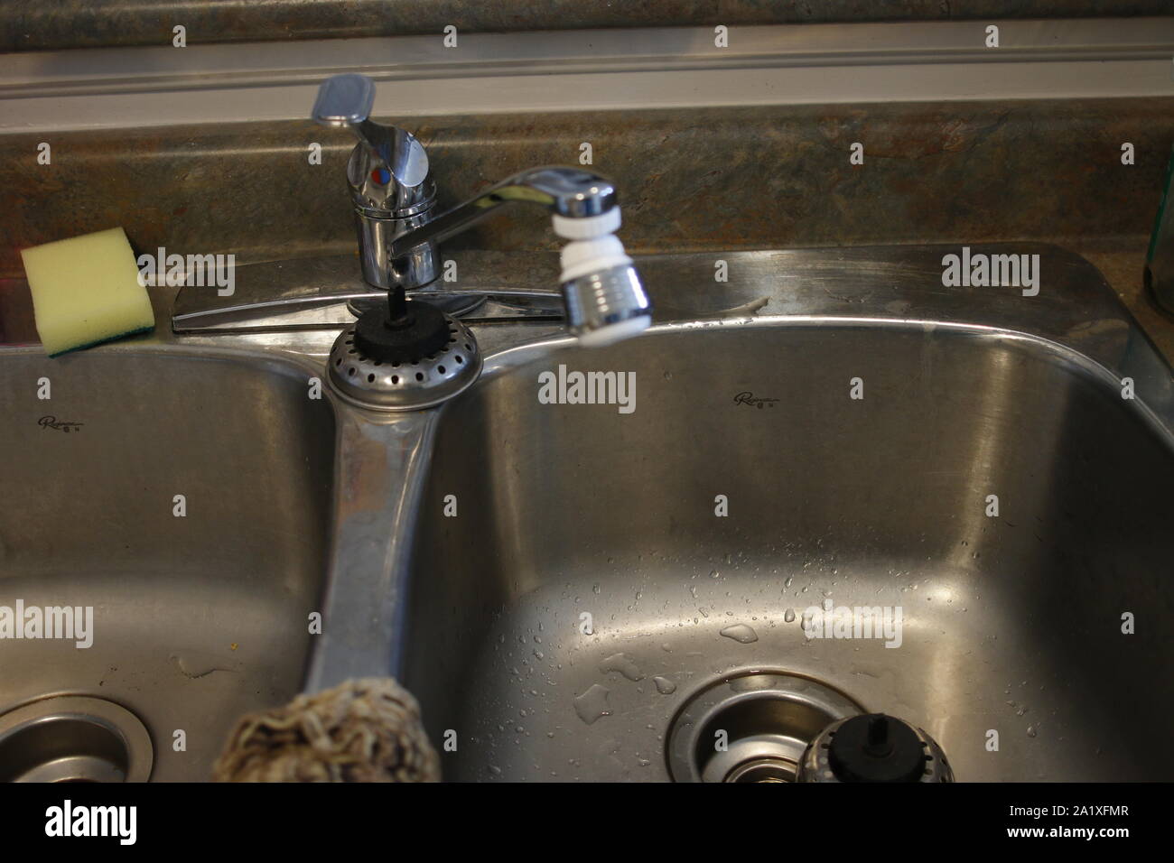 Black kitchen sink and Tap water in the kitchen. The interior of the
