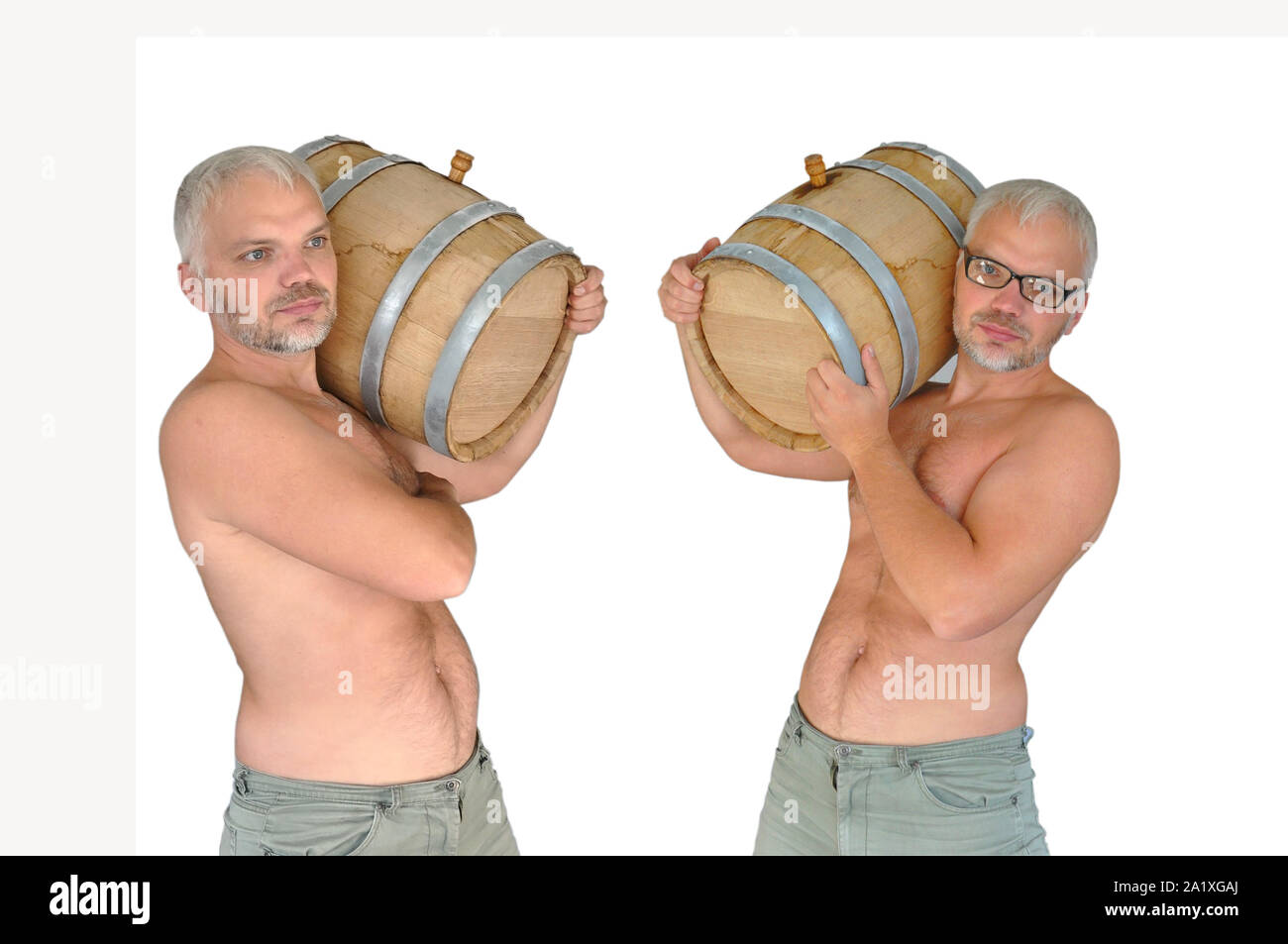 Home wine. Winery concept. A young man with glasses and without wears a wooden oak barrel with wine. Stock Photo