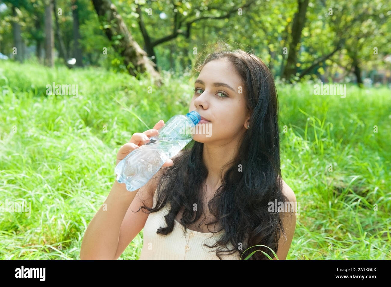 Teen girl drinking water from bottle in summer park. Drinking water in the  heat concept. Close-up Stock Video Footage by ©lizaelesina #489034632