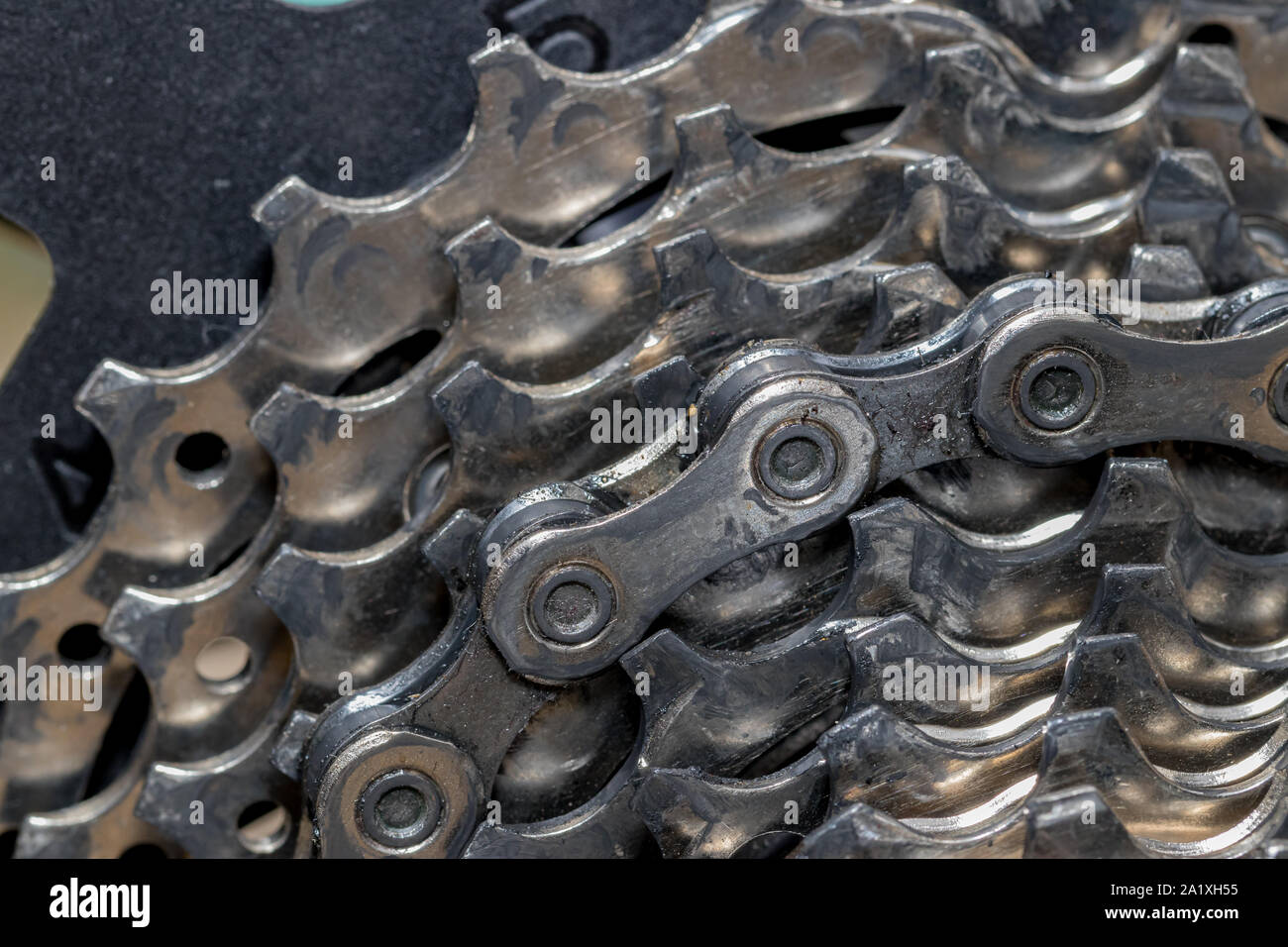 Closeup detail of dirty bicycle cassette gears and chain links covered with dirt, oil, and debris. Concept of cycling maintenance and repair Stock Photo