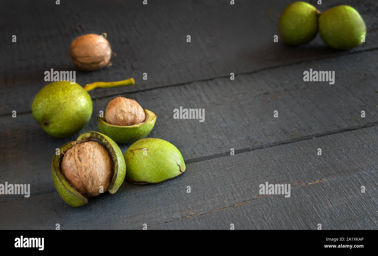 Walnuts in a green shell on a wooden table Stock Photo