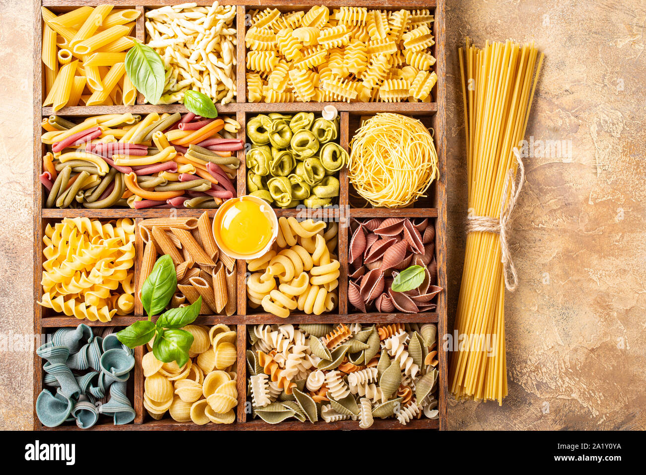 Assorted colorful italian pasta in wooden box Stock Photo