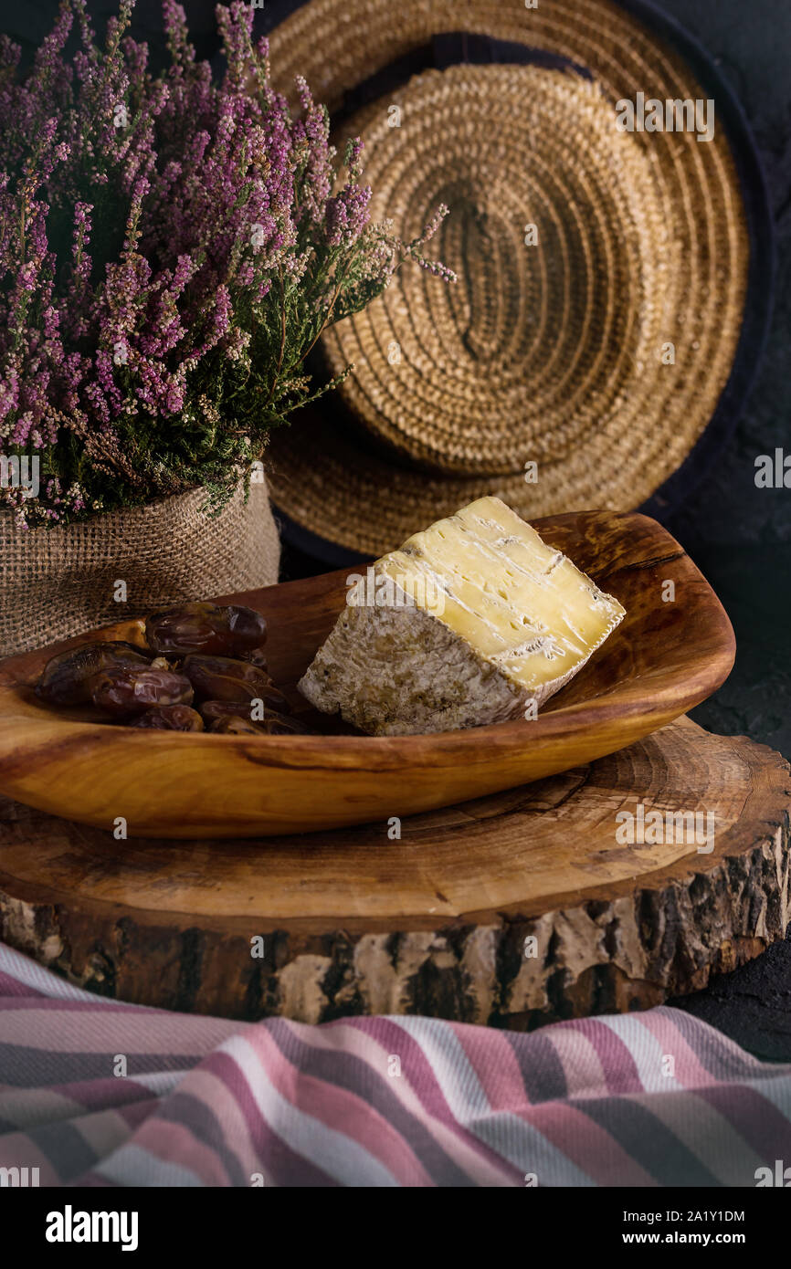 piece of old blue cheese and a branch of dates. Country style Stock Photo