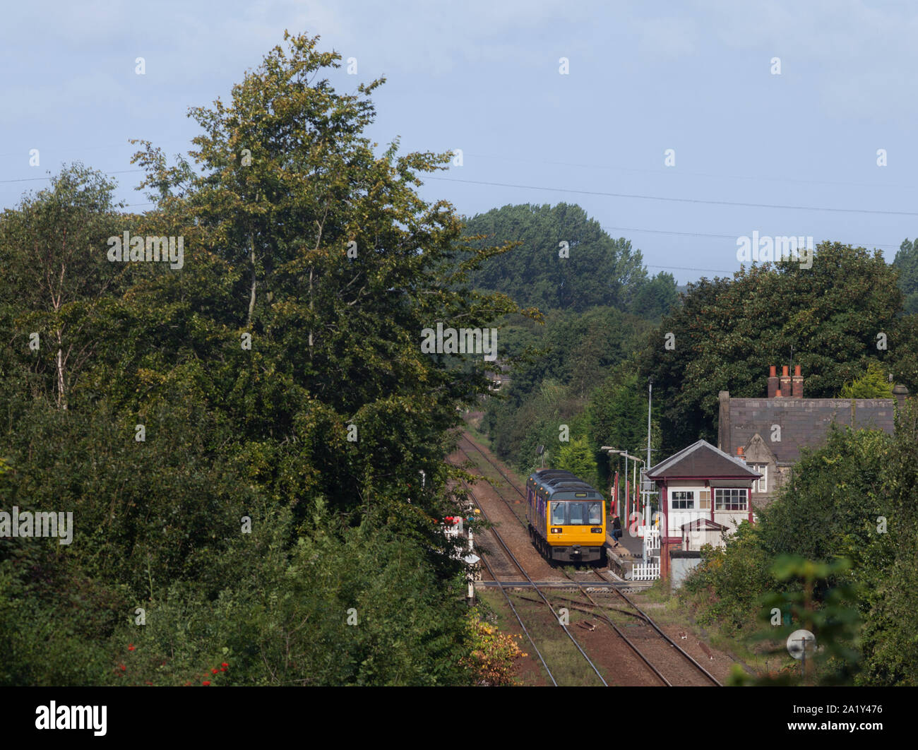 2 Arriva Northern rail class 142 pacer trains calling at  Parbold railway station with the mechanical signalbox visible Stock Photo
