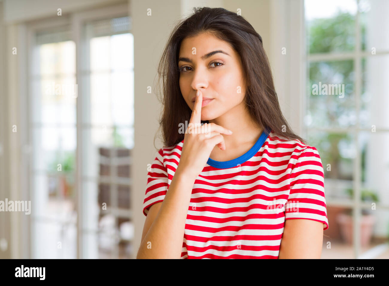 Young beautiful woman thinking and wondering with a hand on chin, doubt concept Stock Photo
