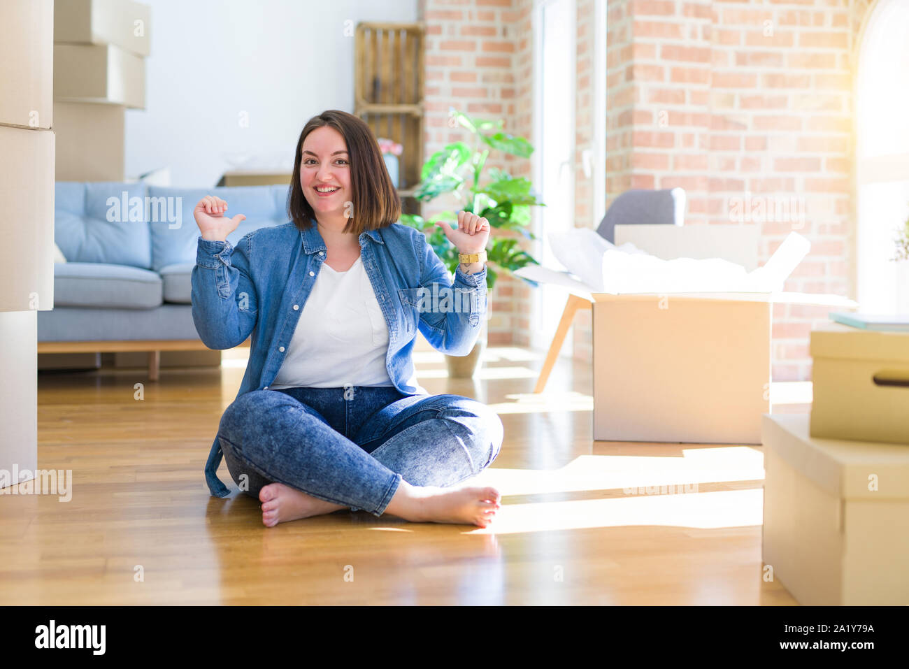 Young Plus Size Woman Sitting On The Floor Around Cardboard Boxes