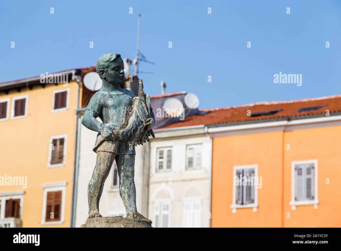 Large fountain of a boy with a fish pictured in Rovinj (Croatia) during September 2019.  Dubrovnik born sculptor Marjan Kocković created the fountain Stock Photo