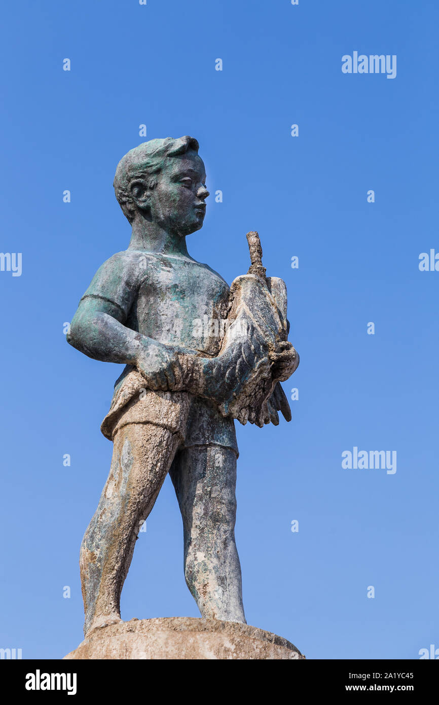 Large fountain of a boy with a fish pictured in Rovinj (Croatia) during September 2019.  Dubrovnik born sculptor Marjan Kocković created the fountain Stock Photo