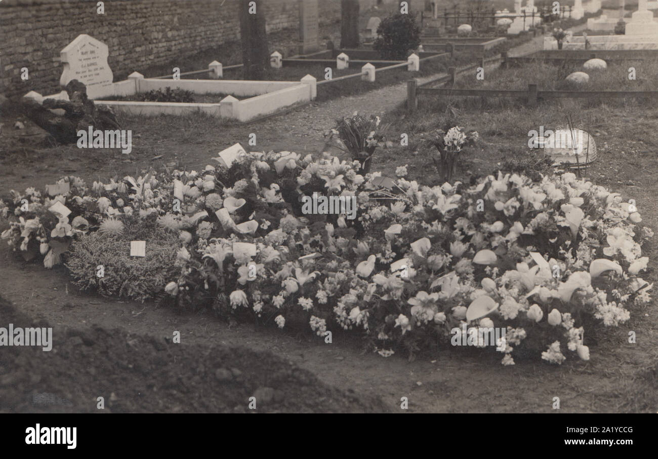 Vintage Early 20th Century Photographic Postcard Showing a British Churchyard Burial. Wreaths Left on The Burial Mound. Stock Photo
