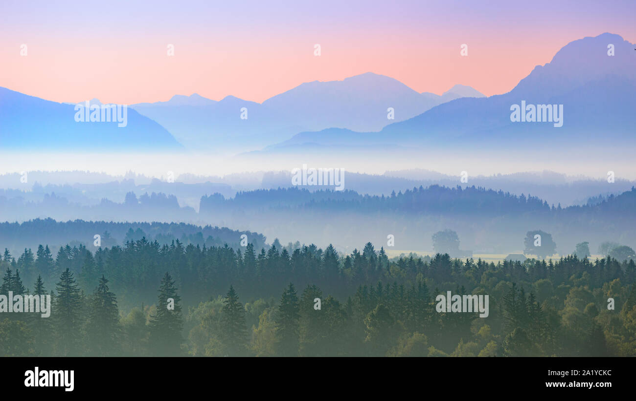 Aerial panoramic landscape of Upper Bavarian foggy foothills with morning sunrise over Alps mountains Stock Photo