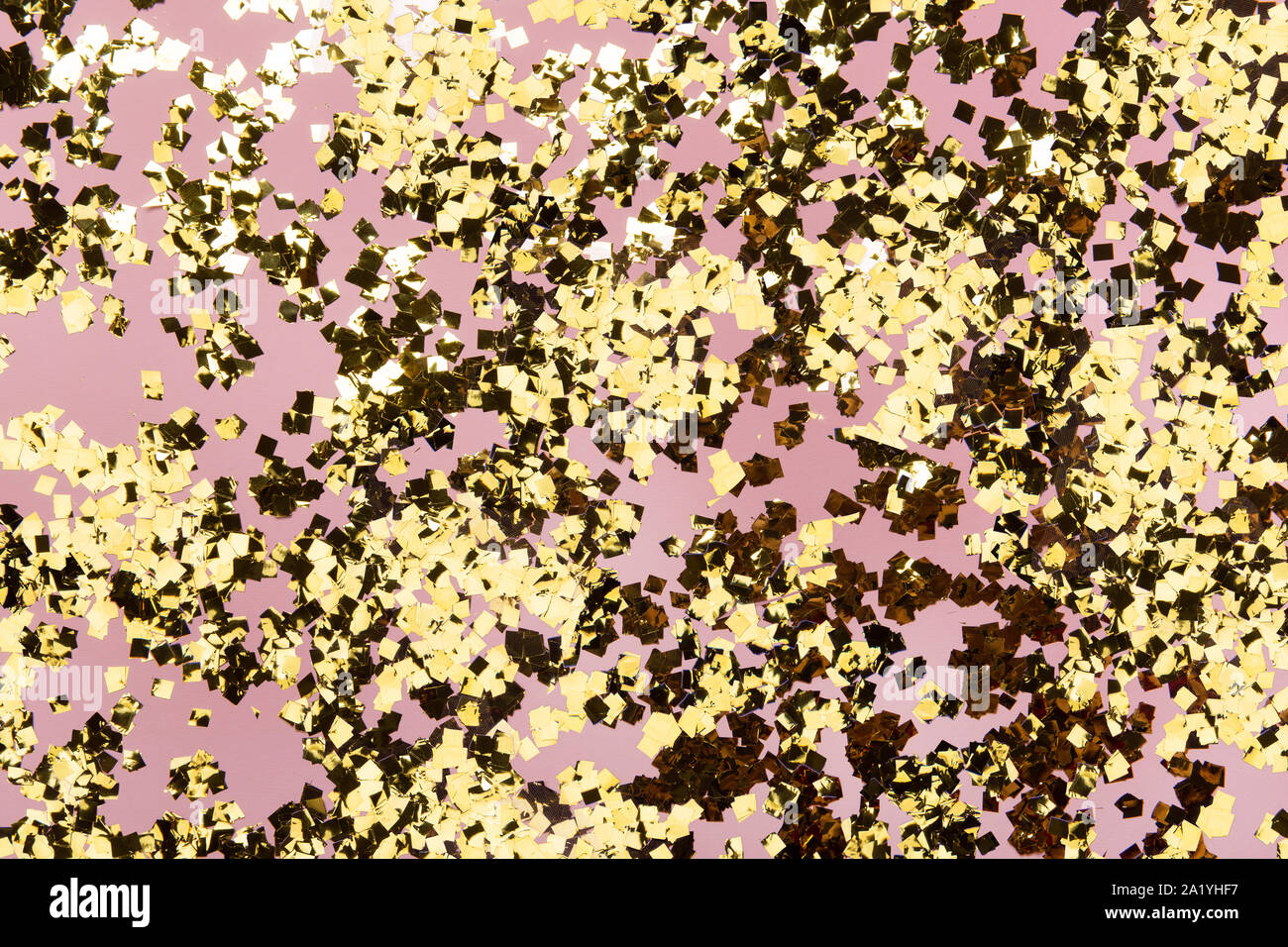 Golden confetti glitter on pink background. Festive holiday pastel ...