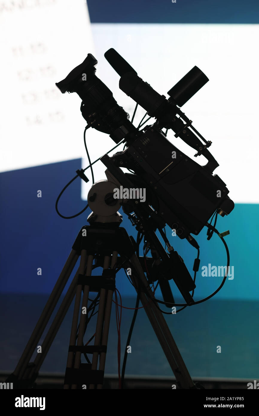 Professional TV camera on the tripod before news briefing. Stock Photo