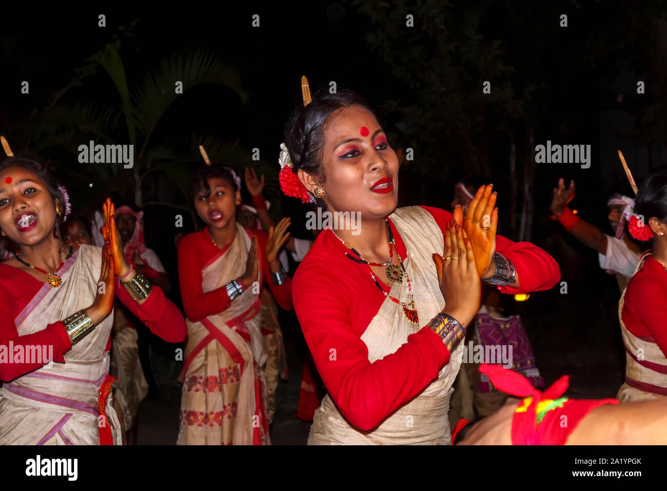 Smiling young local women dancers in traditional dress perform at an Indian New Year dance in Kaziranga, Golaghat District, Bochagaon, Assam, India Stock Photo