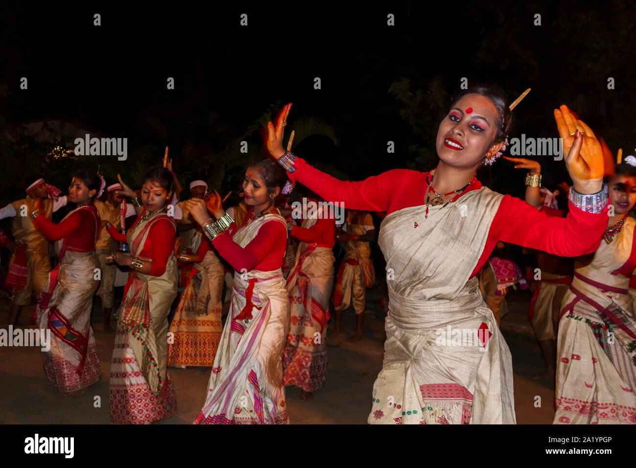 Smiling young local women dancers in traditional dress perform at an Indian New Year dance in Kaziranga, Golaghat District, Bochagaon, Assam, India Stock Photo