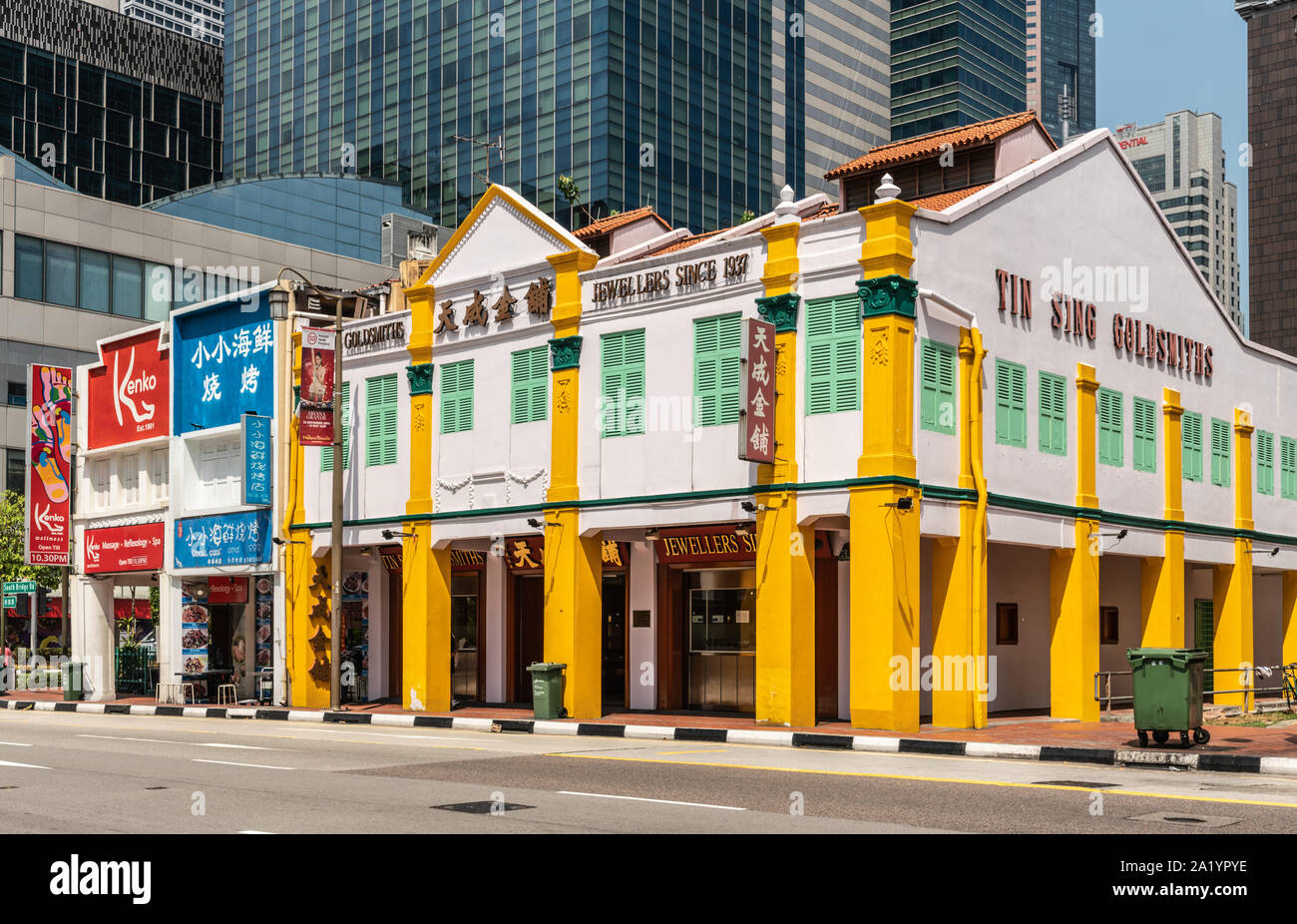 Singapore - March 22, 2019: Chinatown. Yin Sing Goldsmiths and Jewellers on South Bridge Road is large white and yellow corner building. Skyscrapers b Stock Photo