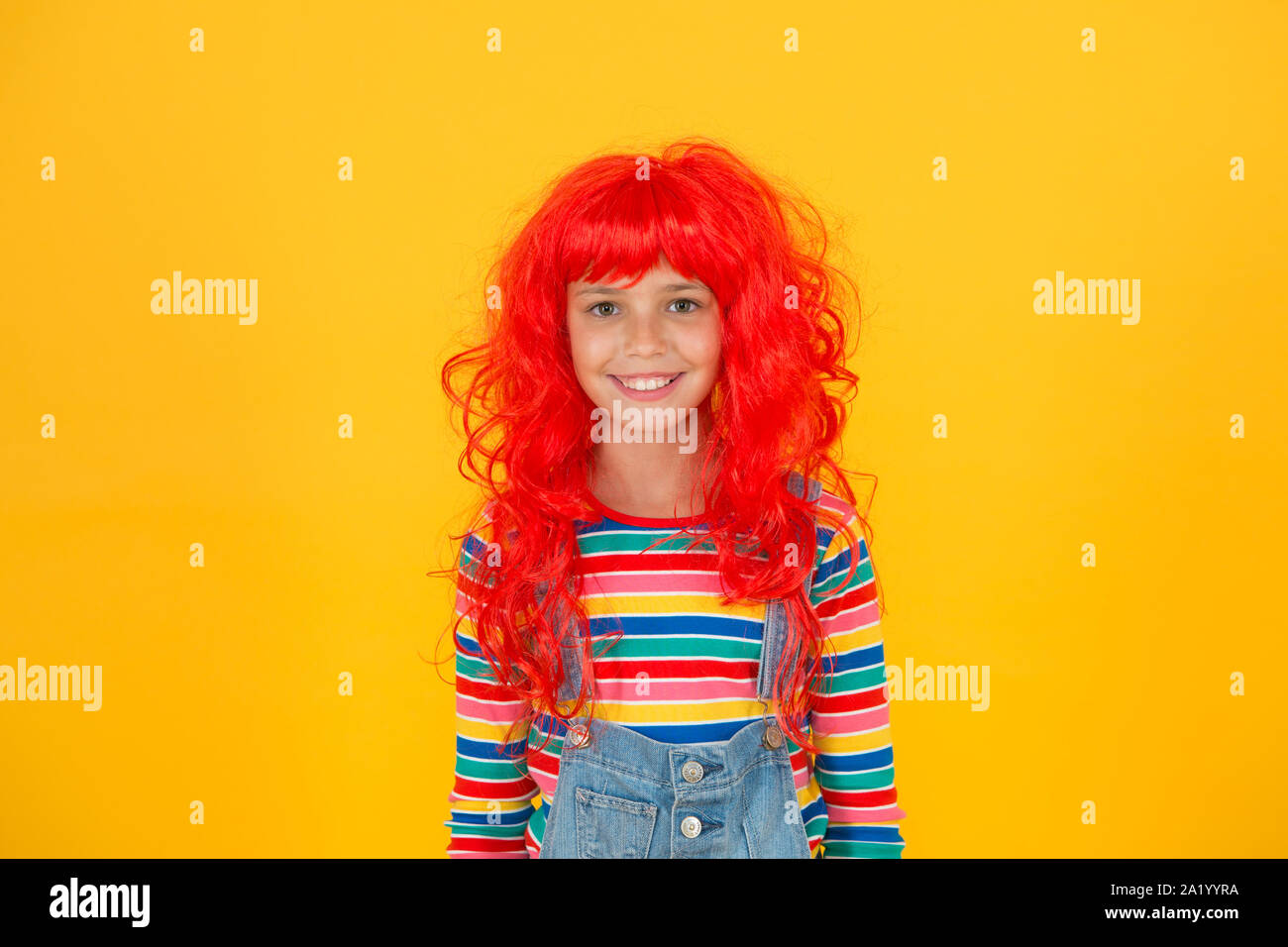 Redhead stereotypes. Redheads are not some creatures with magical soul sucking powers. Crazy redhead wig. Messy hairstyle. Kid cheerful smiling happy redhead girl. I am ginger and proud of it. Stock Photo